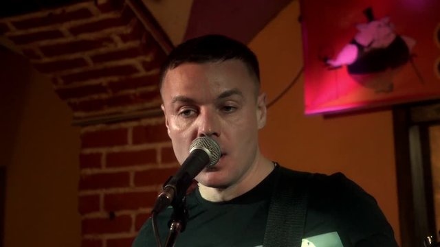 Portrait handsome musician singing song in microphone on rock consert at stage