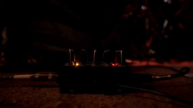 Close up hands musician tuning buttons on music control before rock performance