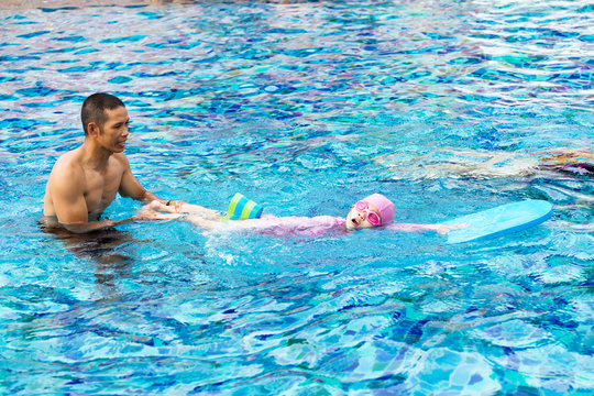 Little girl learning in a swimming pool.