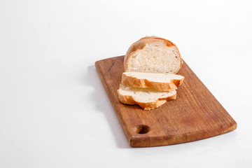 Side view of slices of white bread on a kitchen board, on a white background.