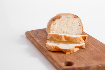 Side view of slices of white bread on a kitchen board, on a white background.
