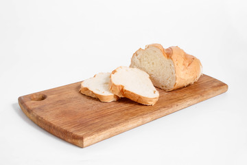 Side view of slices of white bread on a kitchen board, on a white background.