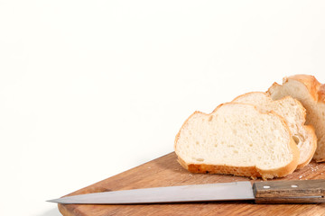 Sliced white bread lying on a kitchen board with a knife side view on a white background