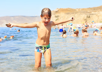Funny face llittle boy enjoy play on beach