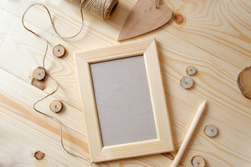 Light wooden frame on a wooden background. Flat lay, top view photo mockup