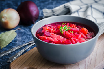 Vegetarian borscht, healthy  beetroot soup on dark blue background. Selective focus, copy space, close up.