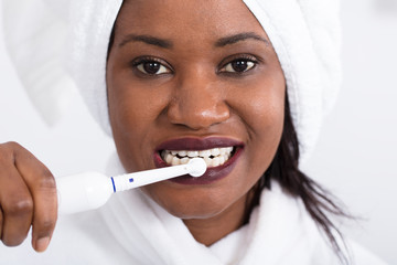 Woman Brushing Teeth With Electrical Toothbrush
