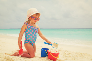 cute little girl play with sand on beach