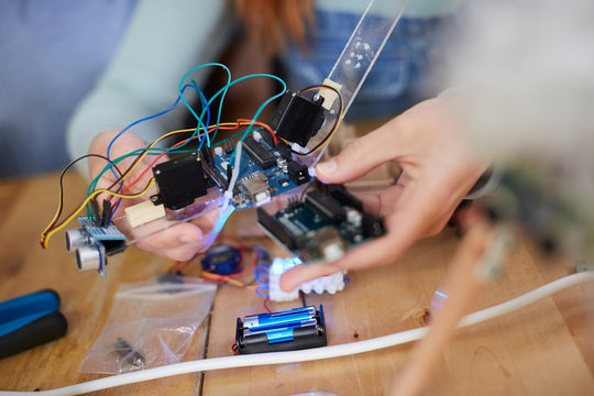 Female engineer holding technology at table in workshop