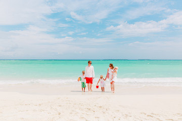 Fototapeta na wymiar happy family with three kids walk on beach