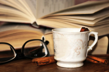 A Cup of coffee, cinnamon sticks and old books