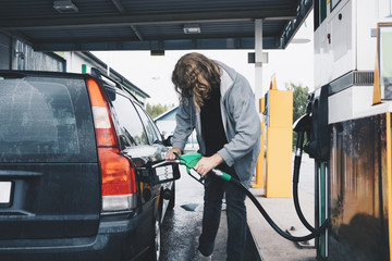Full length of man refueling car at gas station