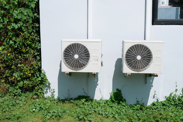 Air conditioner condenser unit at a concrete wall