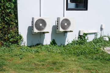 Air conditioner condenser unit at a concrete wall