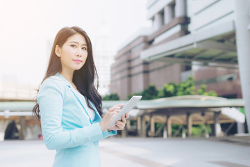 Beautiful cute girl  in business woman clothes  using Tablet phone computer  , urban city background , business concept