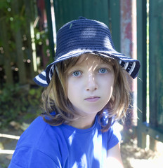 Portrait of a Boy with Blond Hair in Blue Hat