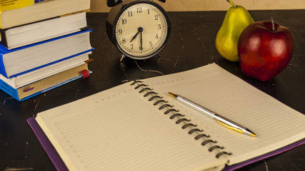 Books, pen, notebook and fruit on the table concept of study