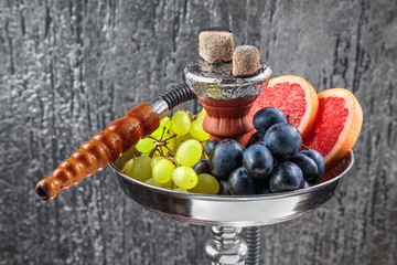 hookah is decorated with grapes and slices of grapefruit
