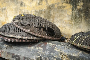 Broken bamboo baskets on ancient stone wall