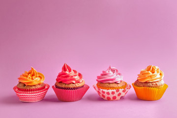 Tasty cupcakes on color background