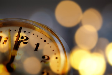 Fototapeta na wymiar new Year's at midnight - clock at twelve o'clock with holiday lights