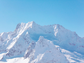 Obraz premium Views of snow capped mountains of Dombay. Winter Sunny day, the Caucasus mountain range, avalanche