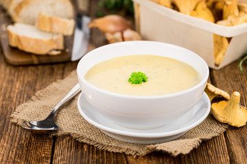 Chanterelle Soup on wooden background; selective focus