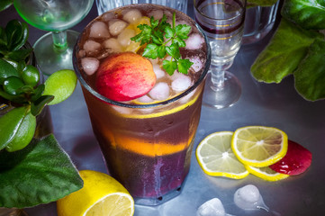 Fruit cocktail at a party, big glasses, lemon and ice on the table