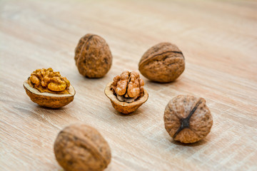 Walnuts shelled and unshelled closeup on a wooden table.