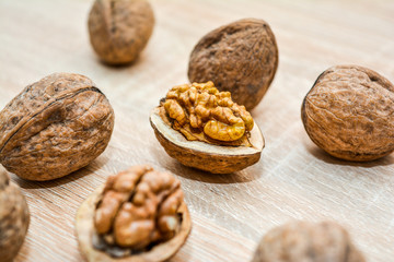 Walnuts shelled and unshelled closeup on a wooden table.