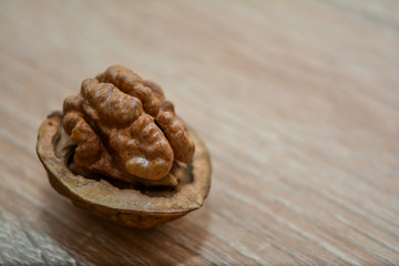 Fototapeta premium Walnut without shells closeup on a wooden table.