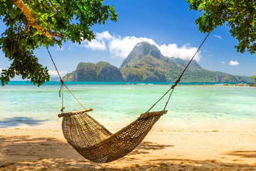 Traditional braided hammock in the shade on a tropical island - obrazy, fototapety, plakaty