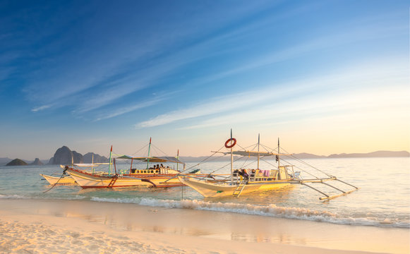 Traditional filipino boats at sunset in Port Barton, Palawan Island, Philippines
