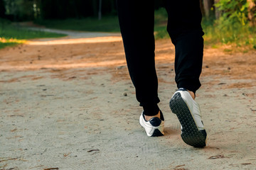 Fototapeta na wymiar Morning jog in the park, men's legs close-up copy space