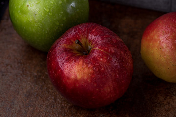 Manzanas rojas y verdes en diferentes superficies con rocio y gotas de agua