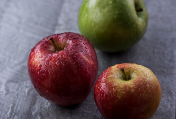 Manzanas rojas y verdes en diferentes superficies con rocio y gotas de agua