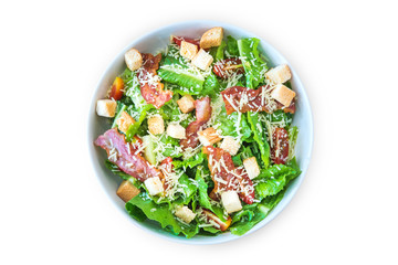 Caesar Salad with Cheese and Bacon on a wooden table.