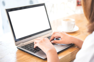 woman hand using laptop with blank white screen on vintage wooden table in cafe,cliping path.