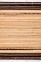 Bamboo mat with curled edges and rope, on white background. Space for text.