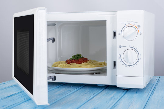 A new white microwave oven, on a blue wooden surface for heating food