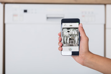 Woman's Hand Showing Dishwasher App
