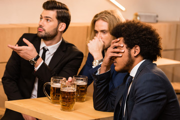 businessmen drinking beer in bar