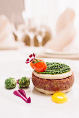 Tasty steak tar tare of raw minced meat. Classic steak beef tar tare with egg on white plate. Raw meat with piece of fresh bread