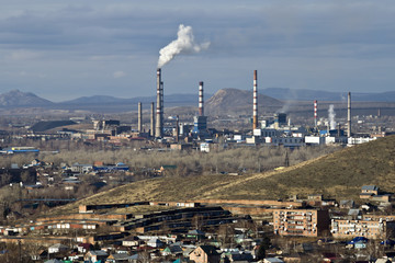 Ust-Kamenogorsk. The industrial center of Kazakhstan. View of the city from the mountain. Pipes and workshops of factories of the industrial zone.