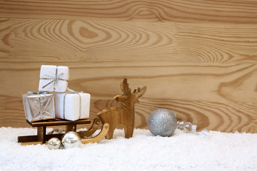 Christmas background with wood deer and gifts on sledge.
