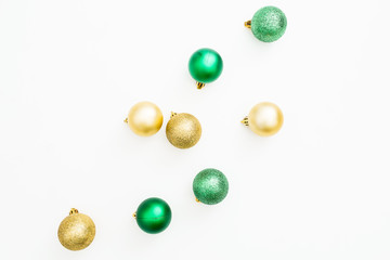 Christmas or New Year composition. Christmas tree decoration, green and golden balls on white background. Flat lay, top view
