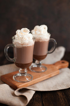 Hot chocolate garnished with whipped cream and cocoa powder.