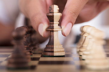 Person Hand Playing Chess And Holding King Chess Piece