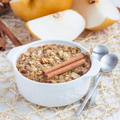 Baked oatmeal with nuts, almond milk, honey, spices and asian pear, square format