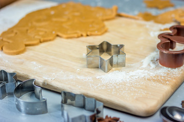 Making christmas gingerbread cookies. Dough and metal cutters on wooden table, horizontal